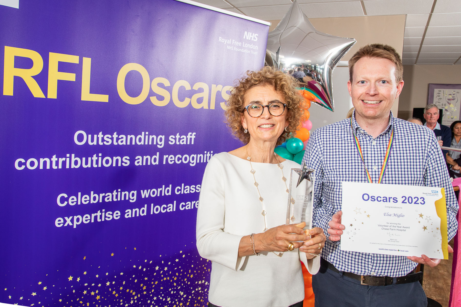 Elsa posing with her certificate and award alongside David Bray